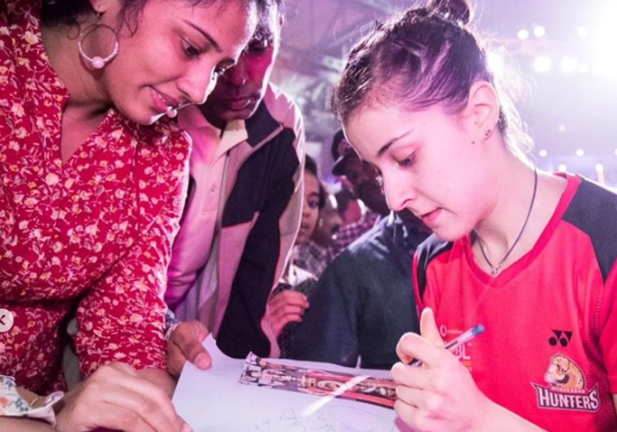 Carolina Marín, firmando un autógrafo a una fan india