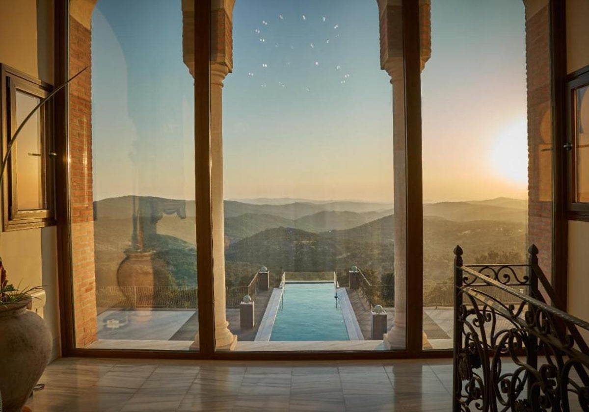 Imagen de la piscina desde el interior del palacete con vistas a la Sierra de Huelva