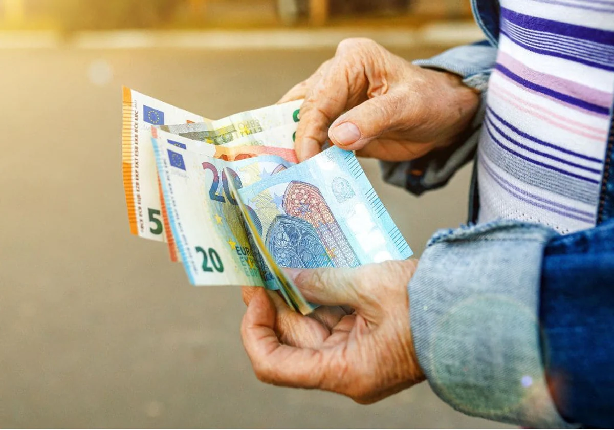 Imagen de archivo de una persona jubilada contando billetes