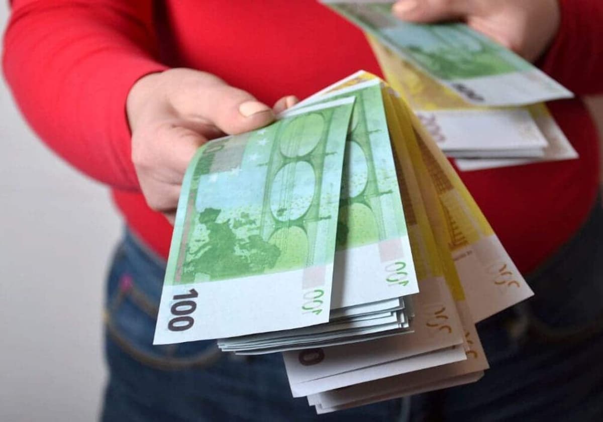 Imagen de archivo de una persona dando billetes