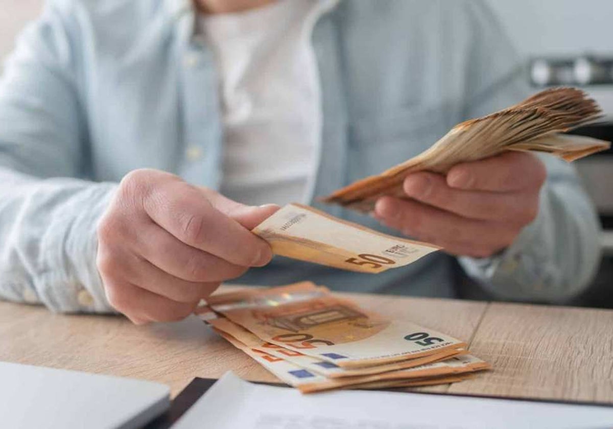 Imagen de archivo de una persona contando dinero en efectivo