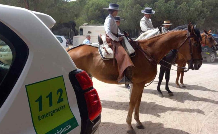 Vehículo de emergencias junto a dos romeros a caballo