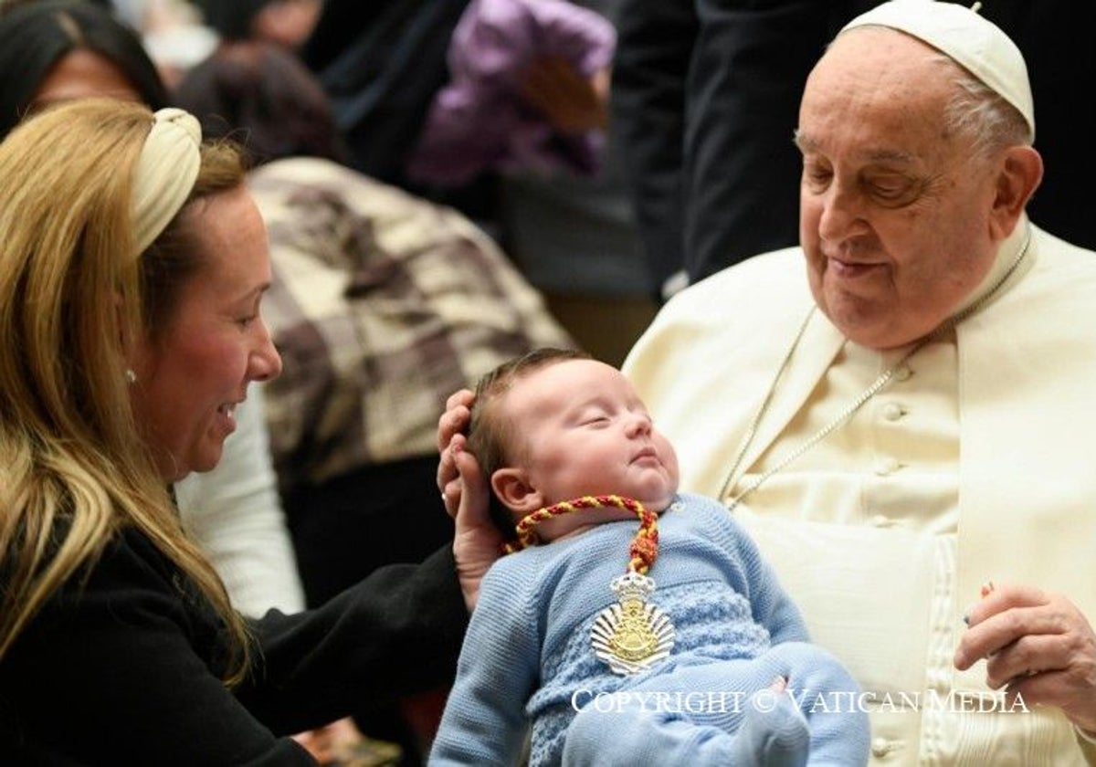 El papa Francisco, con un bebé con la medalla de Emigrantes