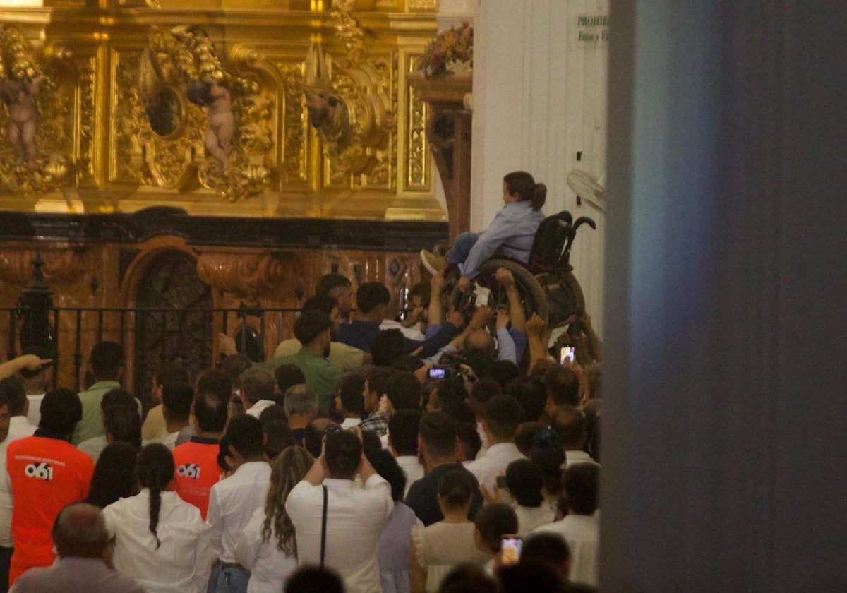Momento en el que los almonteños elevan a una mujer en silla de ruedas para ver mejor a la Virgen del Rocío