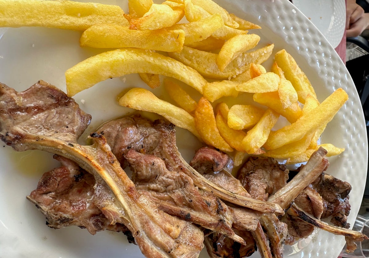Chuletitas de cordero lechal a la brasa con patatas, uno de los platos estrella de la carta de Taberna El Condado en Huelva