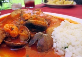 Plato de merluza en salsa con almejas y arroz servido en el restaurante Las Dunas del Portil
