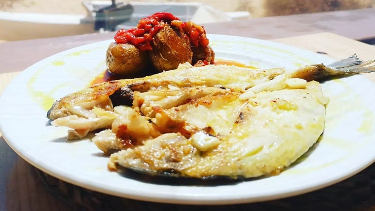 Plato de pescado con guarnición servido en el Chiringuito Costa Colón