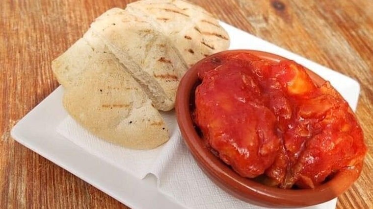 Tapa de bacalao con tomate servida en el bar Los Maestres