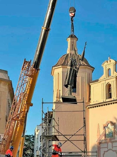 La estatua del almirante es alzada por una grúa para trasladarla a su nueva peana