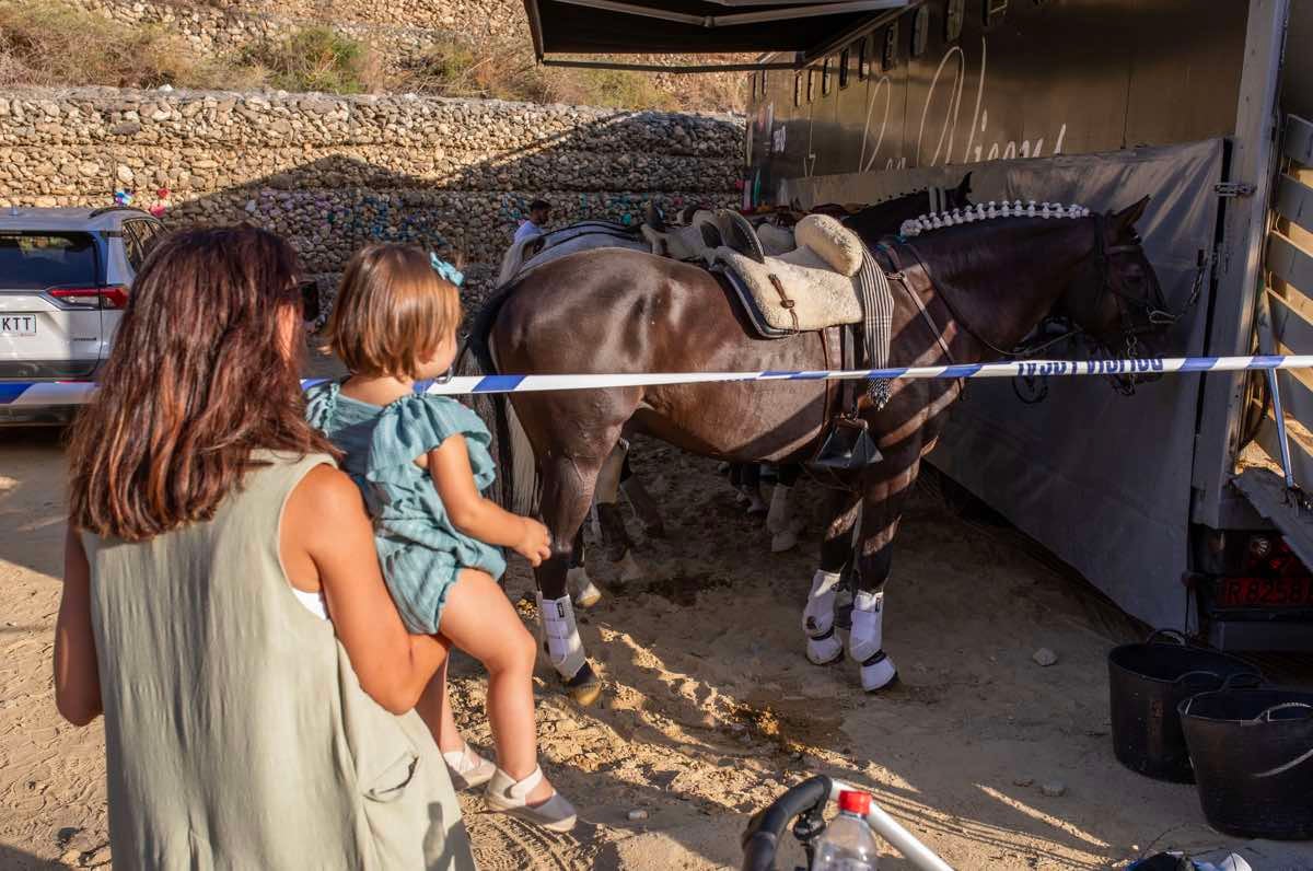 Una mujer muestra a una niña uno de los caballos de la rejoneadora Lea Vicens