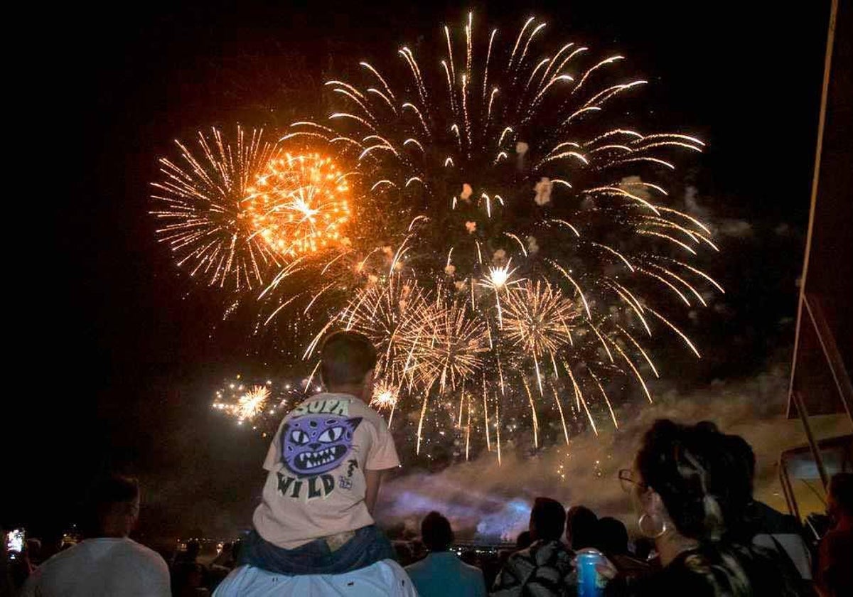 Un niño contempla los fuegos artificiales de Colombinas a hombros de su padre