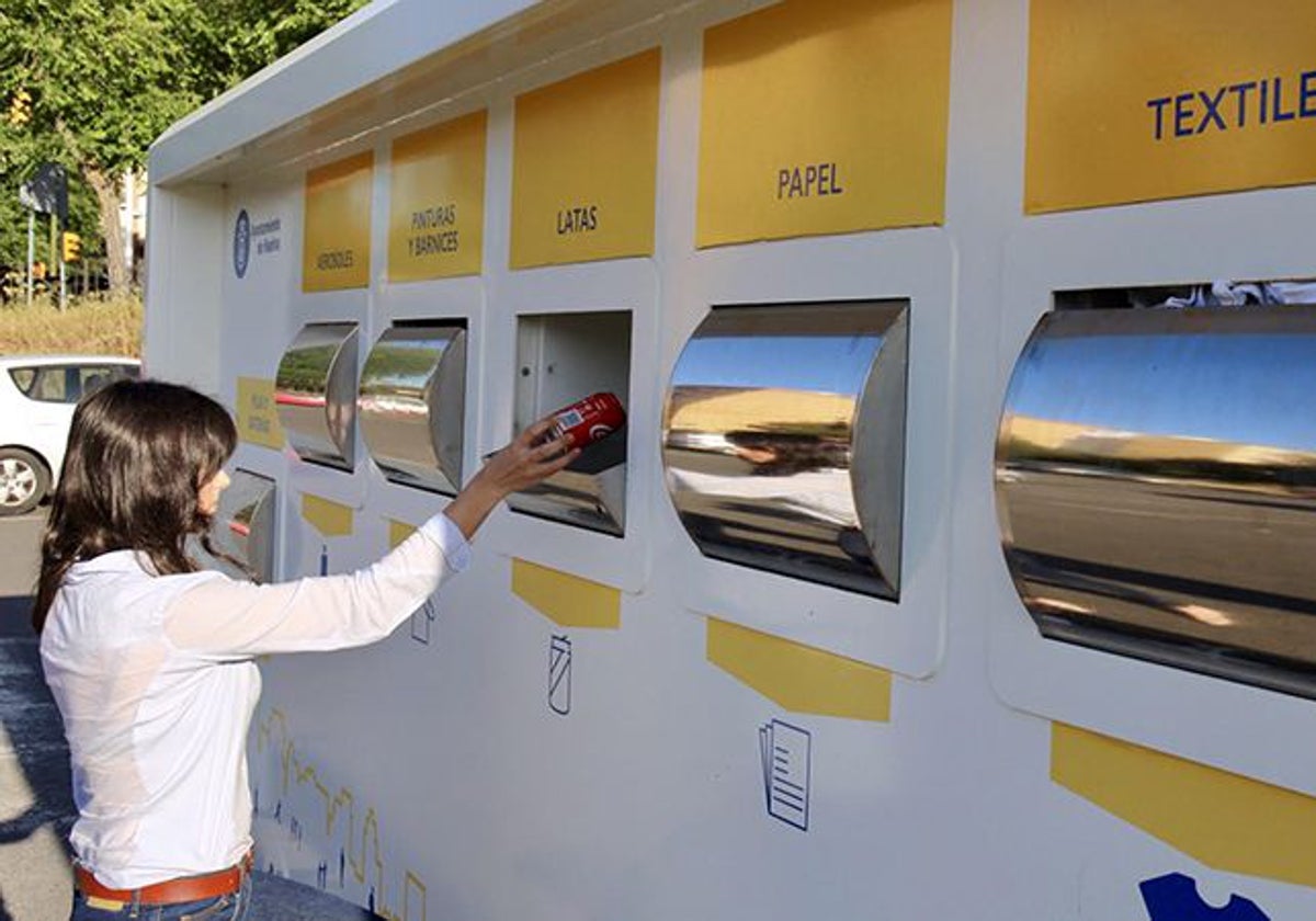 Una vecina deposita una lata en el contenedor