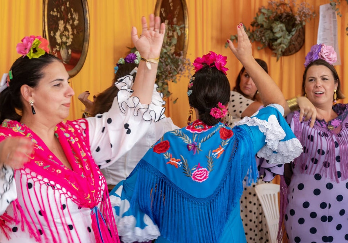 Mujeres bailan en una de las casetas de la Feria de Otoño de Huelva