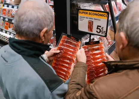 Imagen secundaria 1 - Arriba, ambiente a las puertas del supermercado Supeco. Abajo, dos clientes miran el precio del jamón y otro selecciona los tomates para su compra