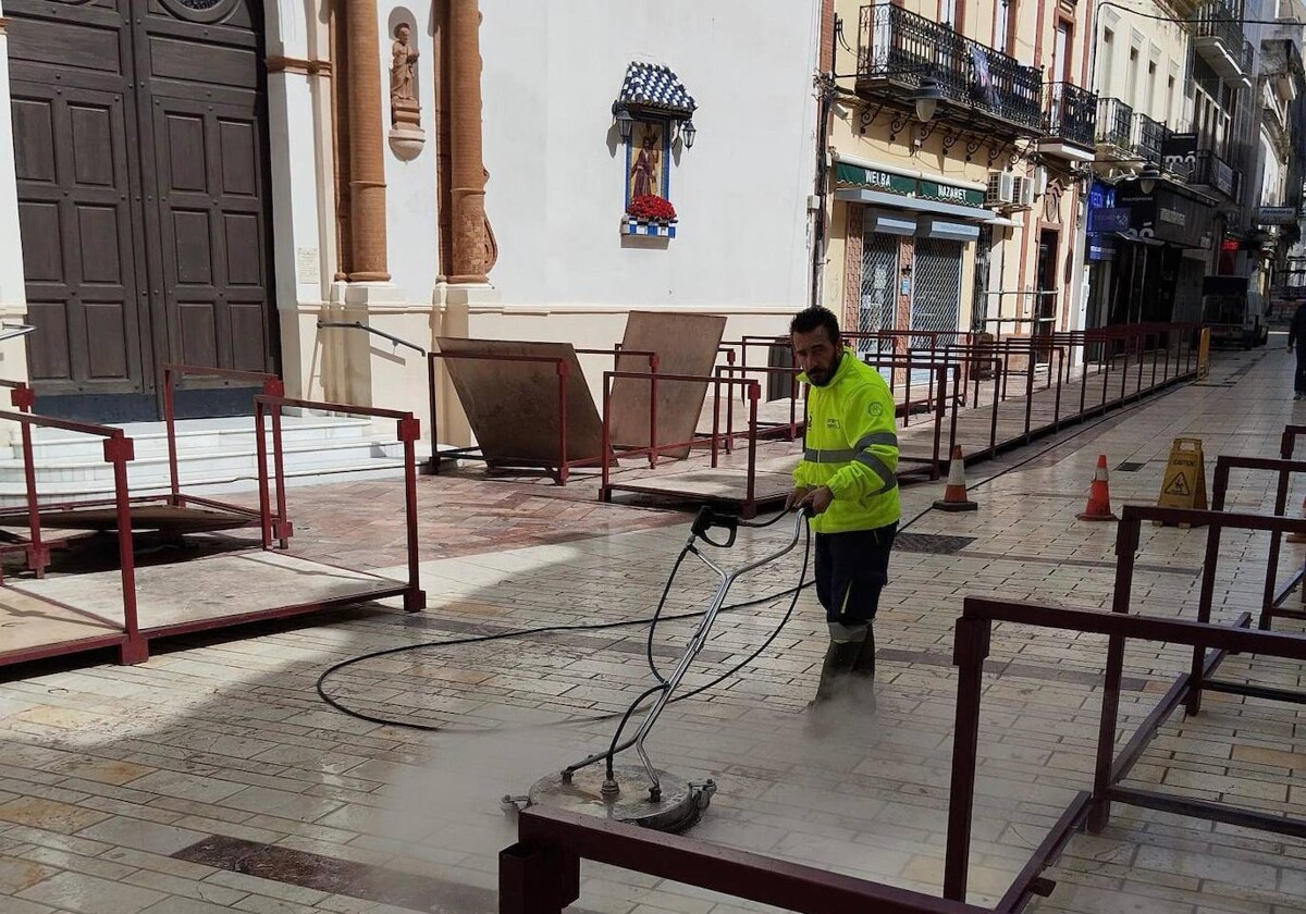 Un operario limpia la cera de la calle Concepción