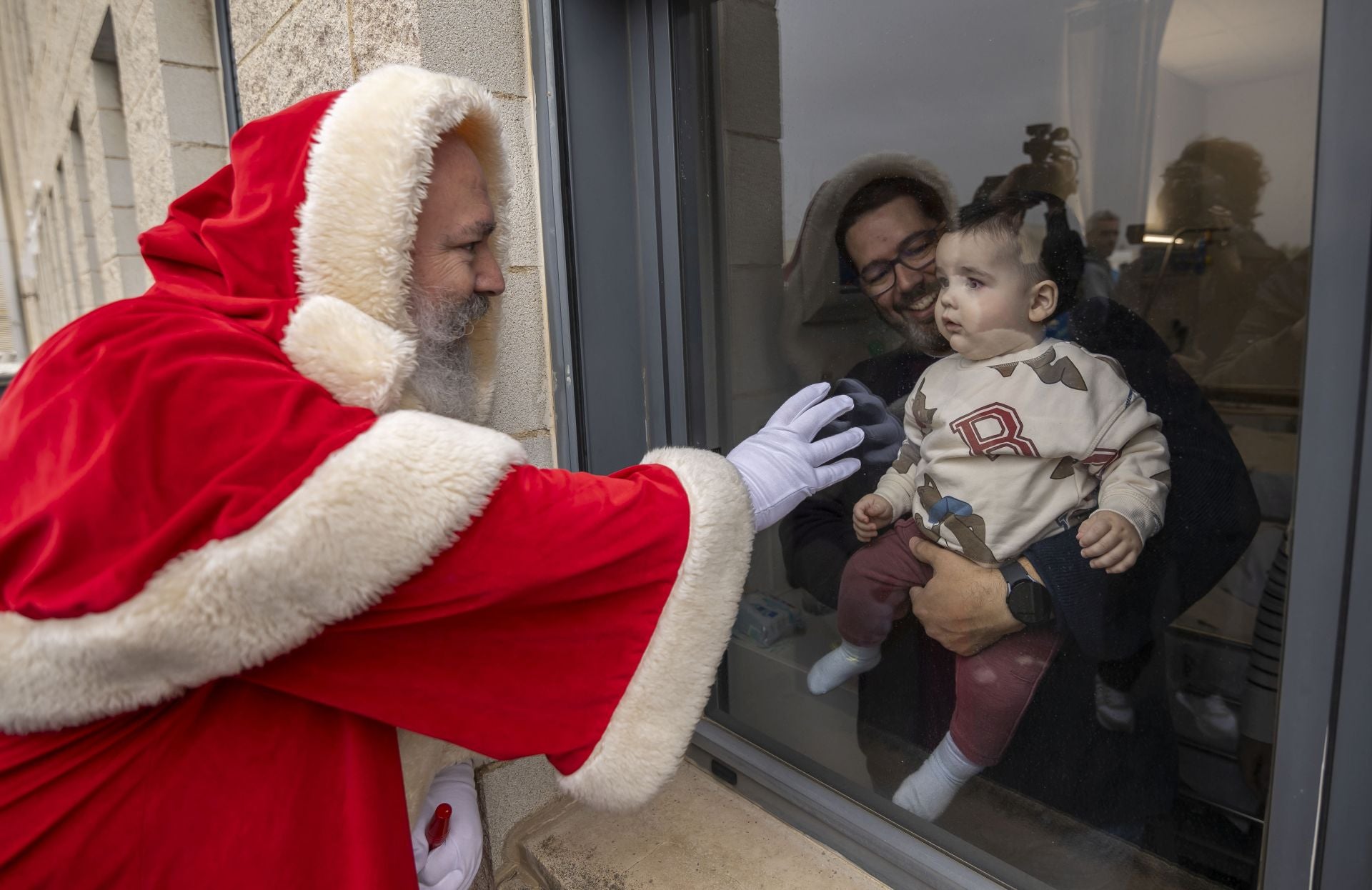 La visita de Papá Noel a los niños ingresados en el Hospital Juan Ramón Jiménez, en imágenes