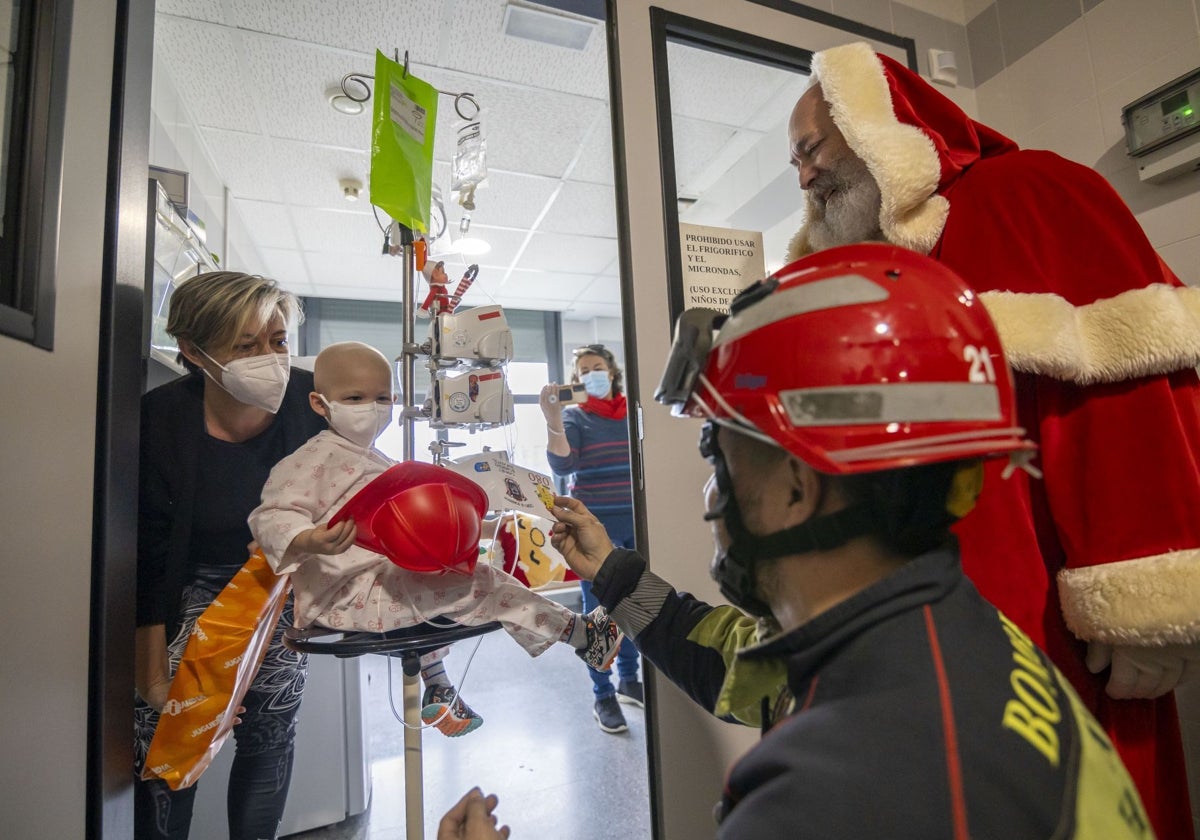 Papá Noel, acompañado de un bombero, visitan a un niño hospitalizado en Huelva