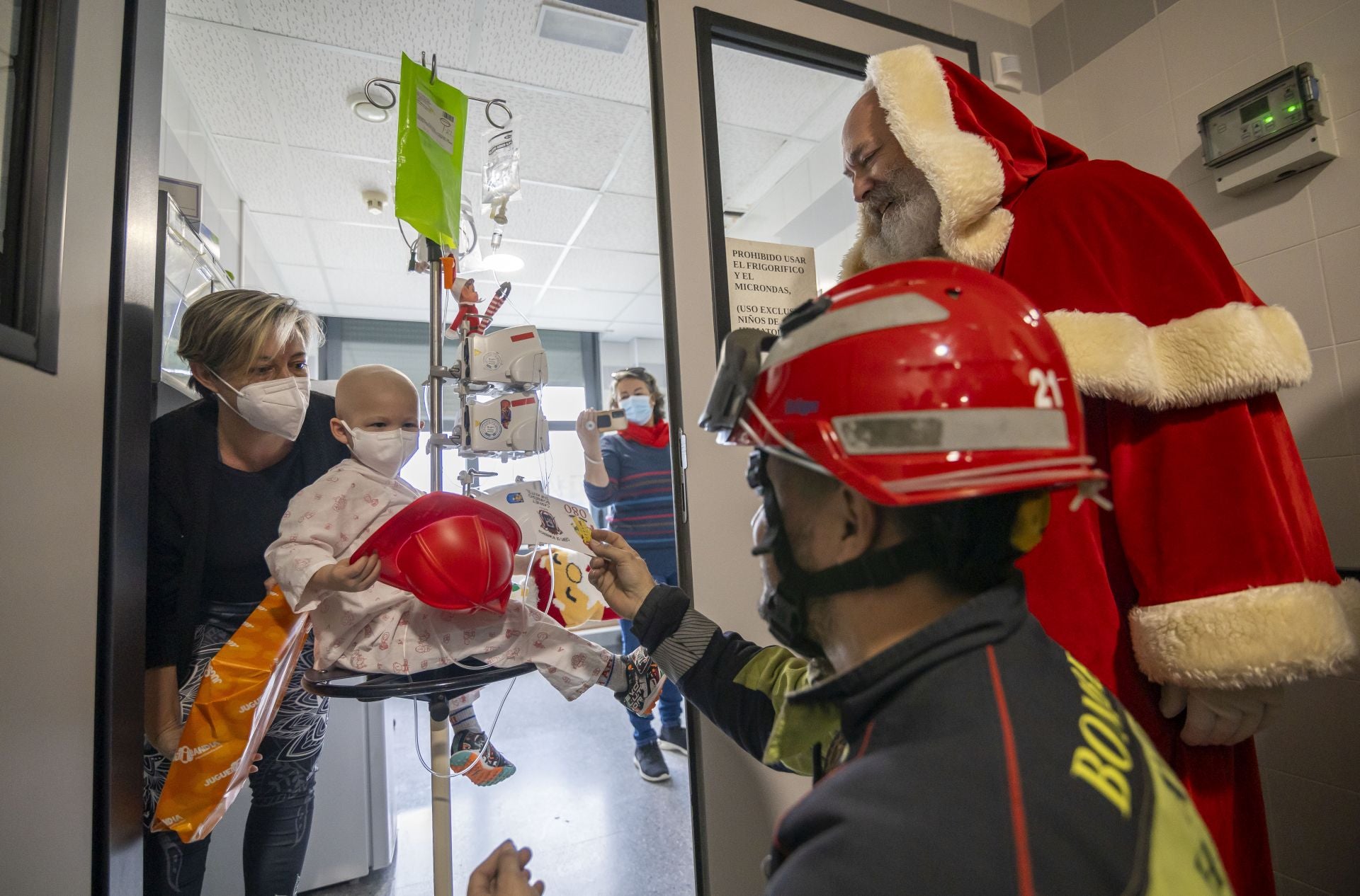 La visita de Papá Noel a los niños ingresados en el Hospital Juan Ramón Jiménez, en imágenes