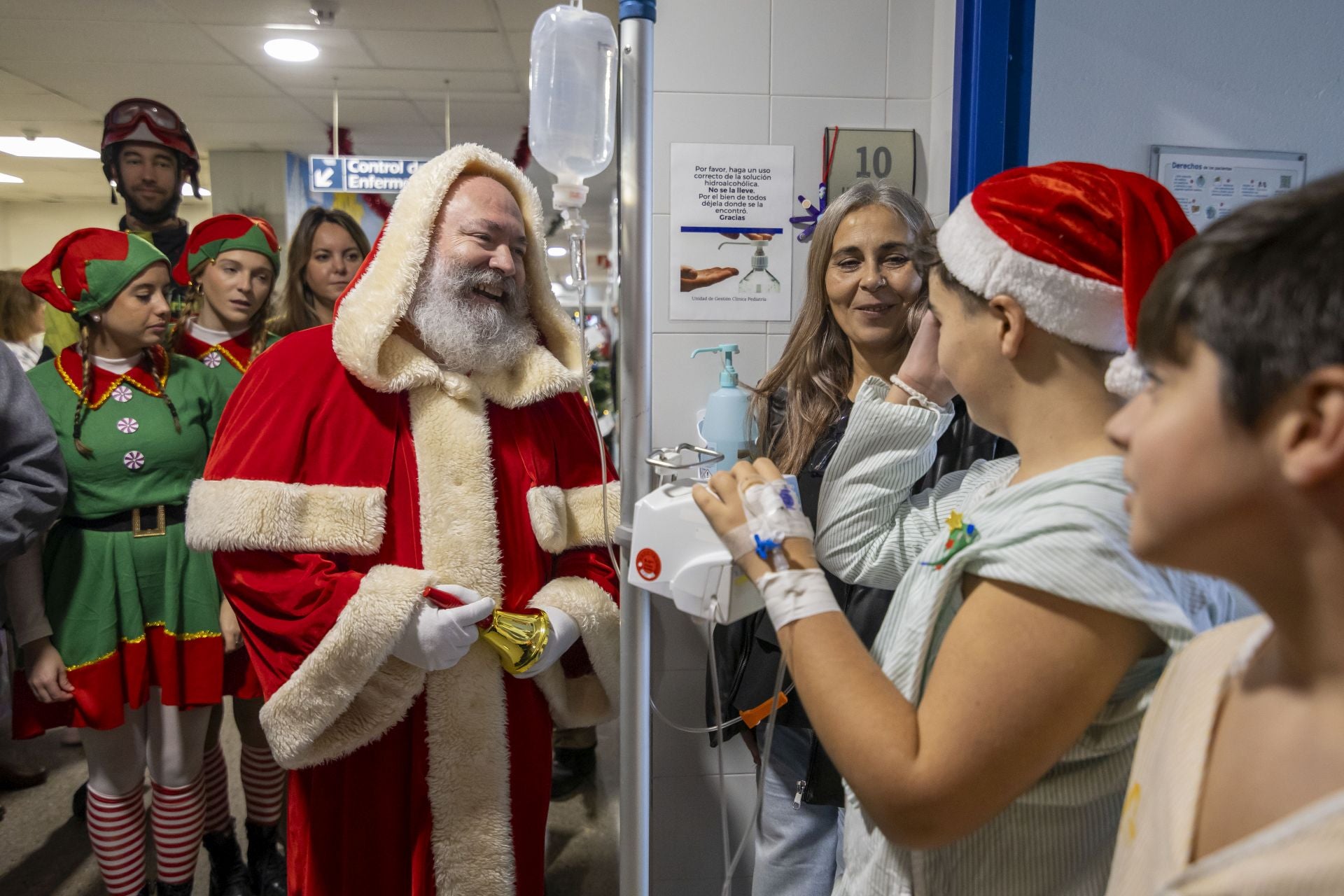 La visita de Papá Noel a los niños ingresados en el Hospital Juan Ramón Jiménez, en imágenes