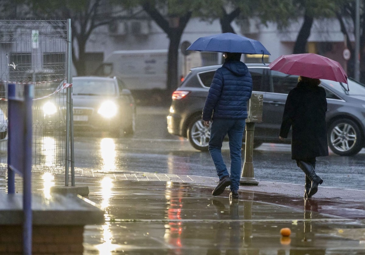 Onubenses caminando por la ciudad bajo la lluvia