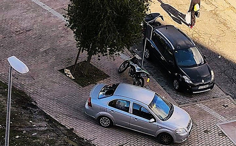 Imagen principal - El descampado de propiedad privada en el que aparcan algunos conductores en la zona del cruce de la barriada de Santa Marta provoca que incluso se monten en la acera con su vehículo y muy cerca de los viandantes