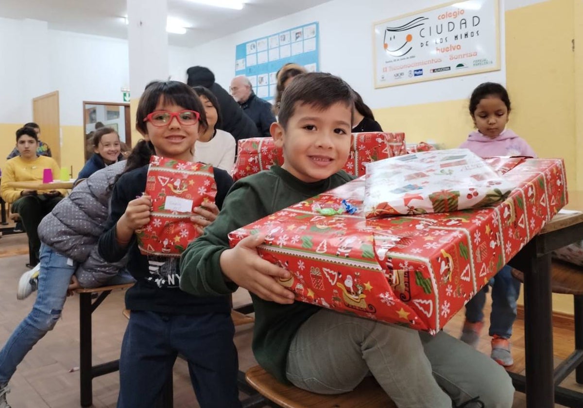 Alumnos del colegio Ciudad de los Niños de Huelva sonrientes con los regalos de los Reyes Magos