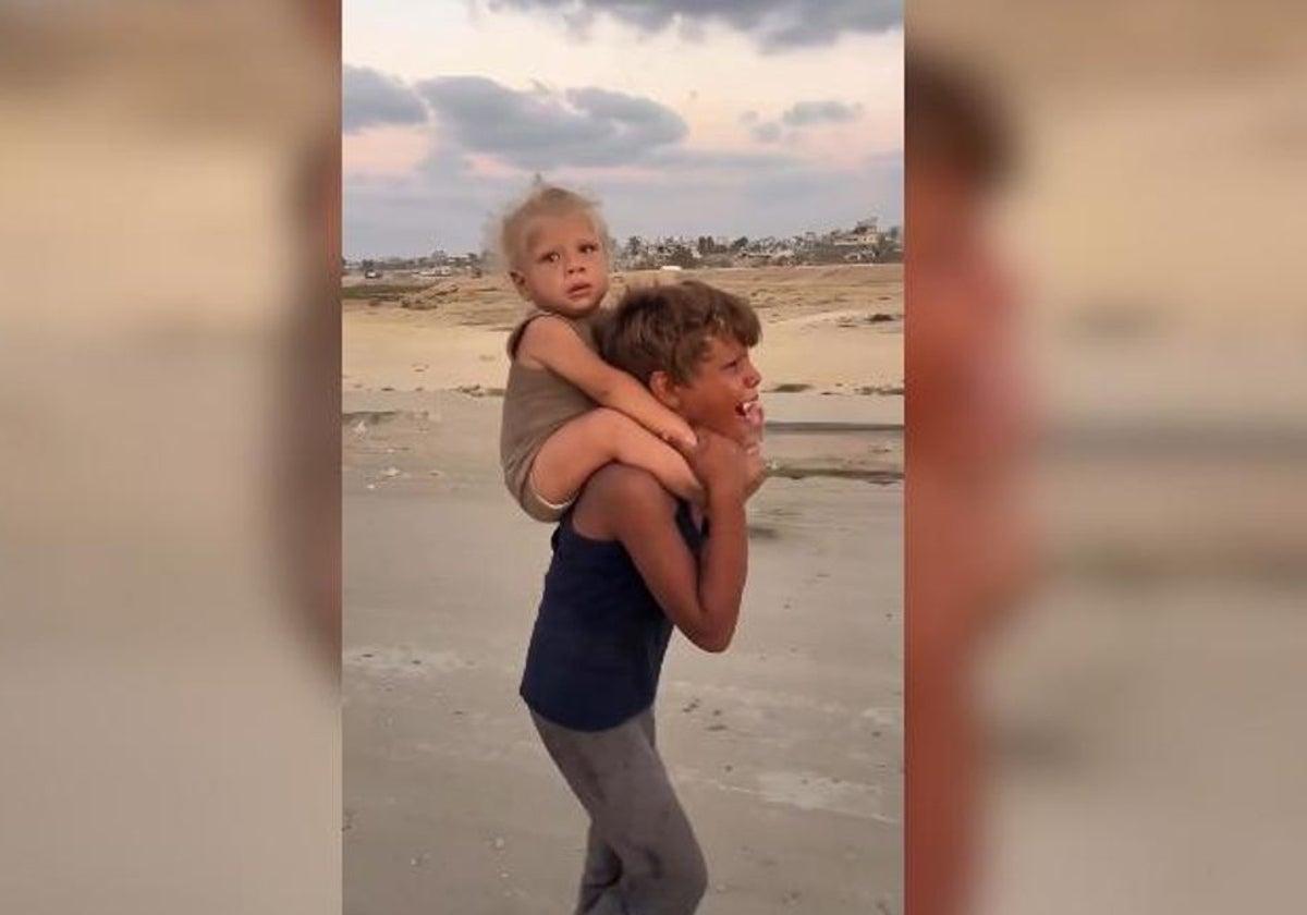 Jadoua, de 8 años, con su hermano Khaled a hombros