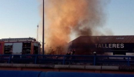 Los bomberos intervienen en la extinción de un incendio en un asentamiento junto a un puente en Huelva