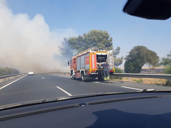 Un incendio de pastos y cunetas en la salida de Huelva hacia Sevilla provoca varios minutos de retenciones