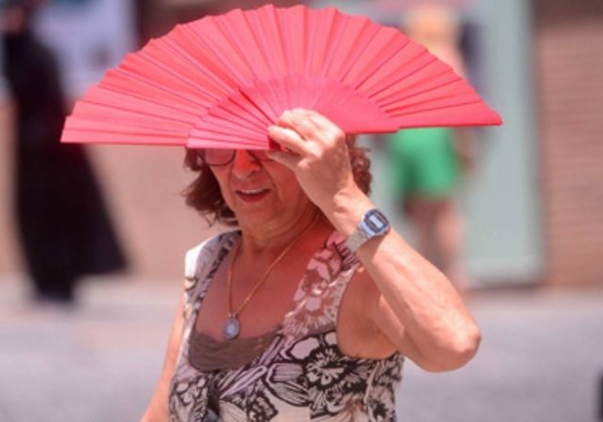 Una mujer se protege del sol con un abanico