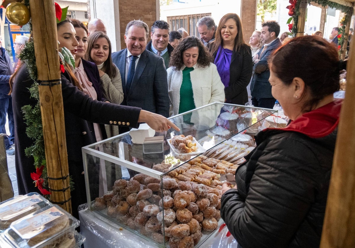 Autoridades onubenses visitan uno de los puestos de la muestra de dulces navideños