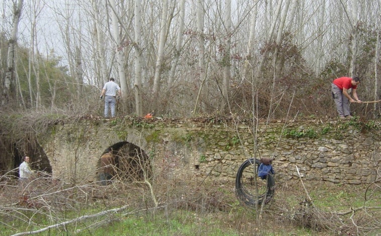 Imagen principal - Limpieza del acueducto de riego entre Galaroza y Fuenteheridos, organización de bibliotecas serranas con donaciones bibliográficas de Lieva y Colaboradores de Lieva montando una exposición en 'La Taberna Cultural'.