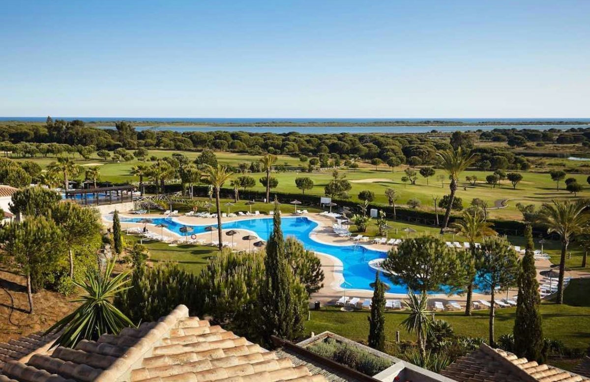 Junto al hotel, el campo de golf, un bosque de pinos y al fondo el Atlántico tras la Flecha de El Rompido