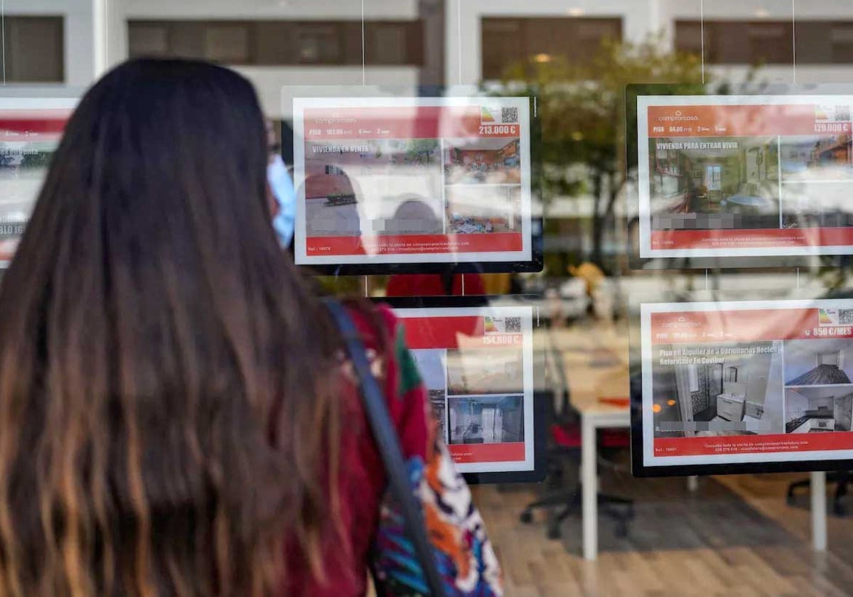 Una joven ante el escaparate de una inmobiliaria