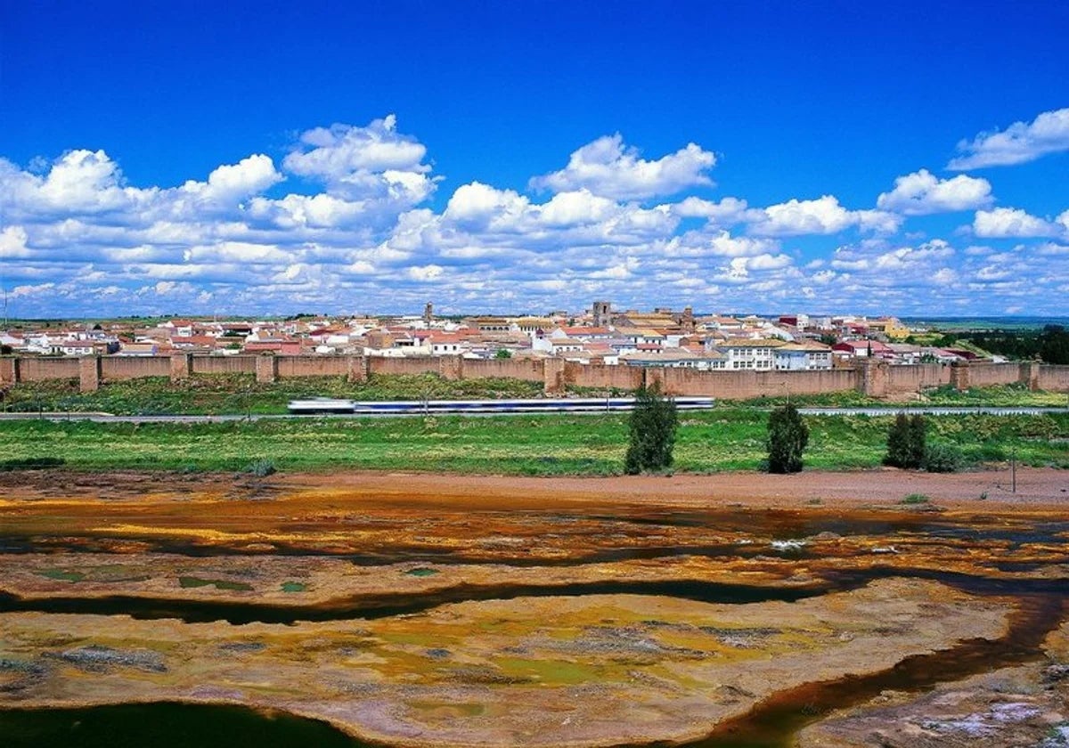 Niebla tras sus murallas, con el río Tinto en primer plano