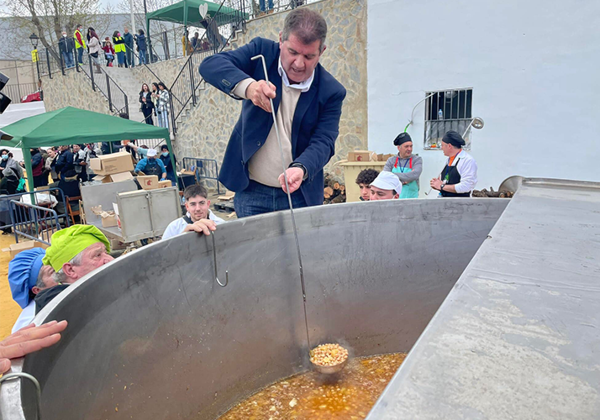 El alcalde de Jabugo, Gilberto Domínguez, sirve un plato de cocido en una anterior edición del evento