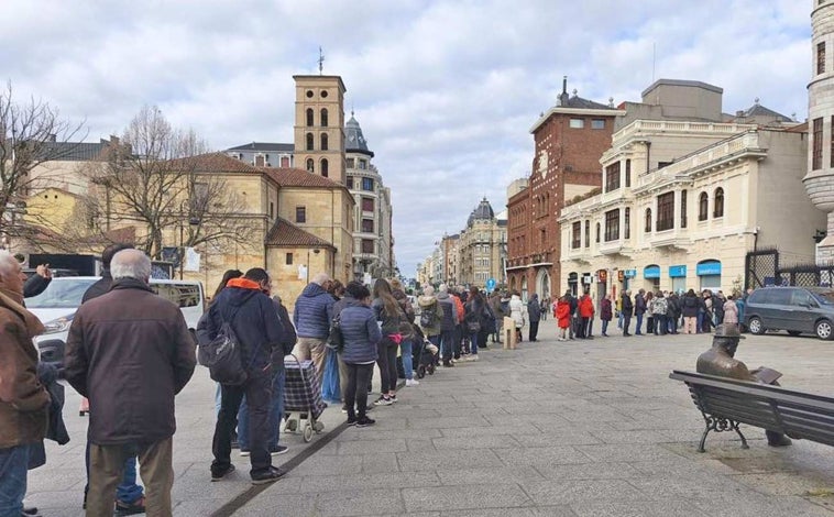 Imagen principal - Arriba, la larga cola que se formó para recoger una de las tarrinas que se regalaron el jueves en el centro de León y sobre estas líneas, el 'stand' de la UPA y la mascota de la campaña fotografiándose con vecinos de la capital leonesa