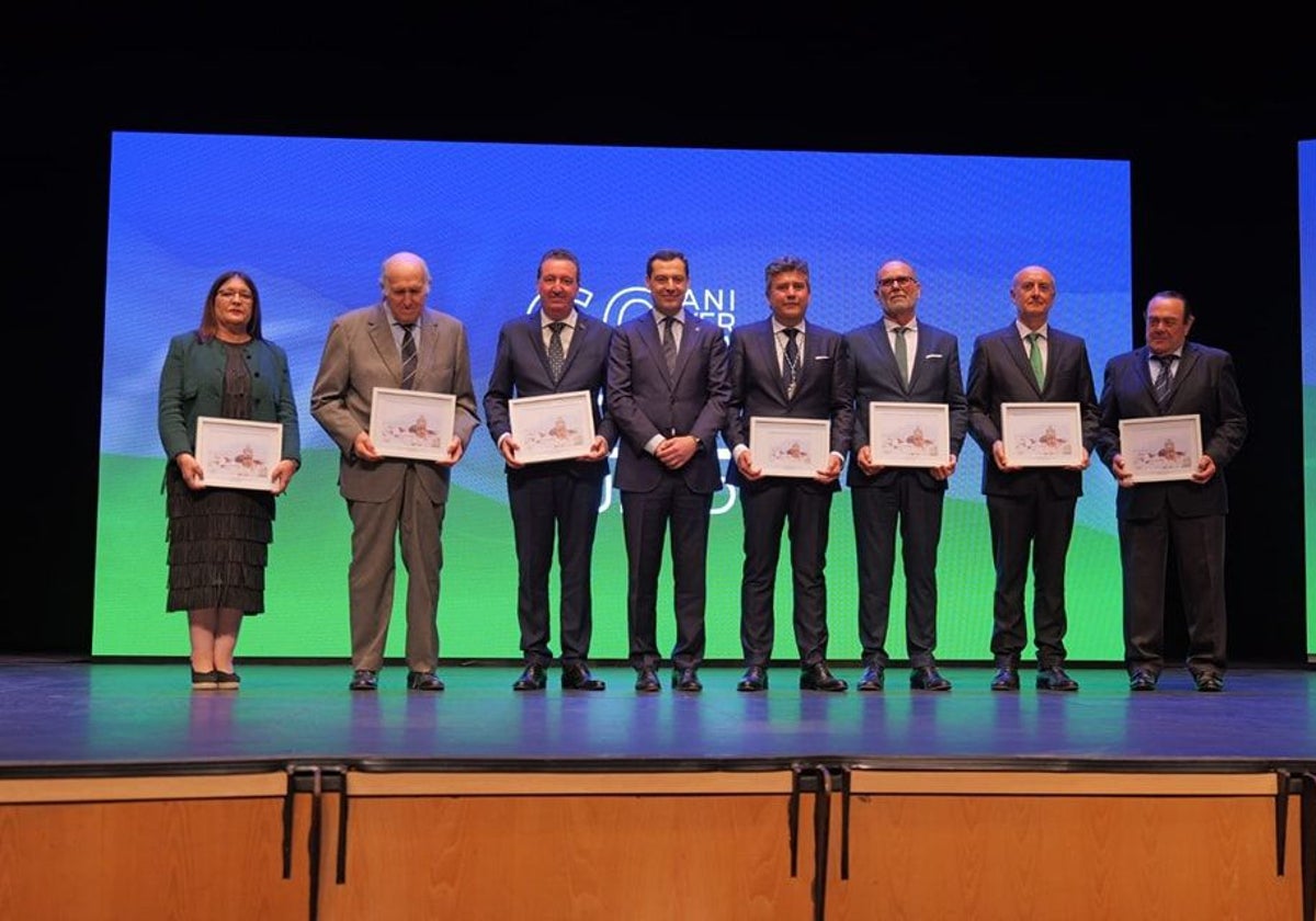 El presidente de la Junta de Andalucía, Juanma Moreno, con regidores de Lepe en diferentes épocas, durante el acto institucional conmemorativo del 60 aniversario de la concesión del título de ciudad al municipio