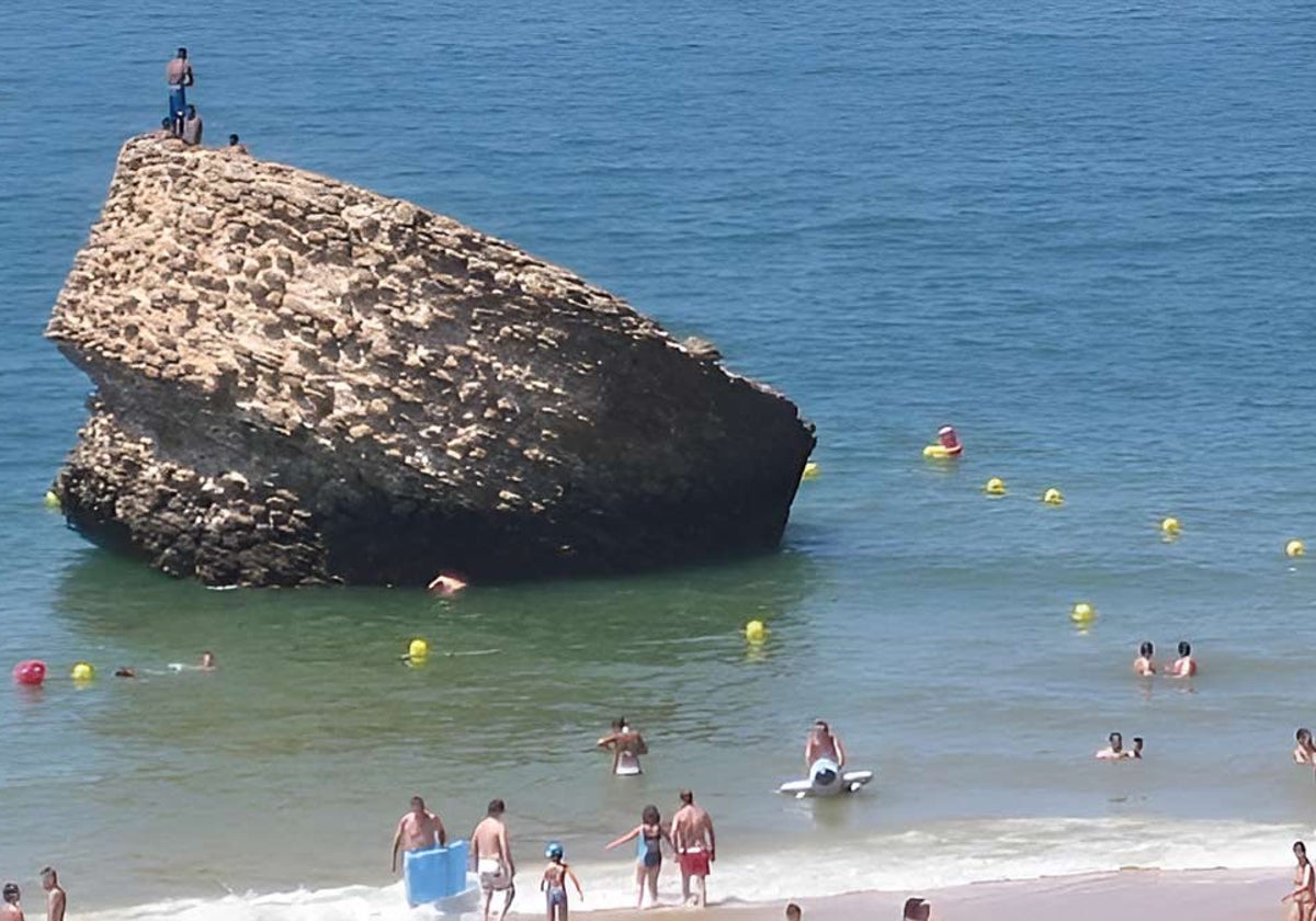 Un grupo de personas encaramadas a los restos de torre