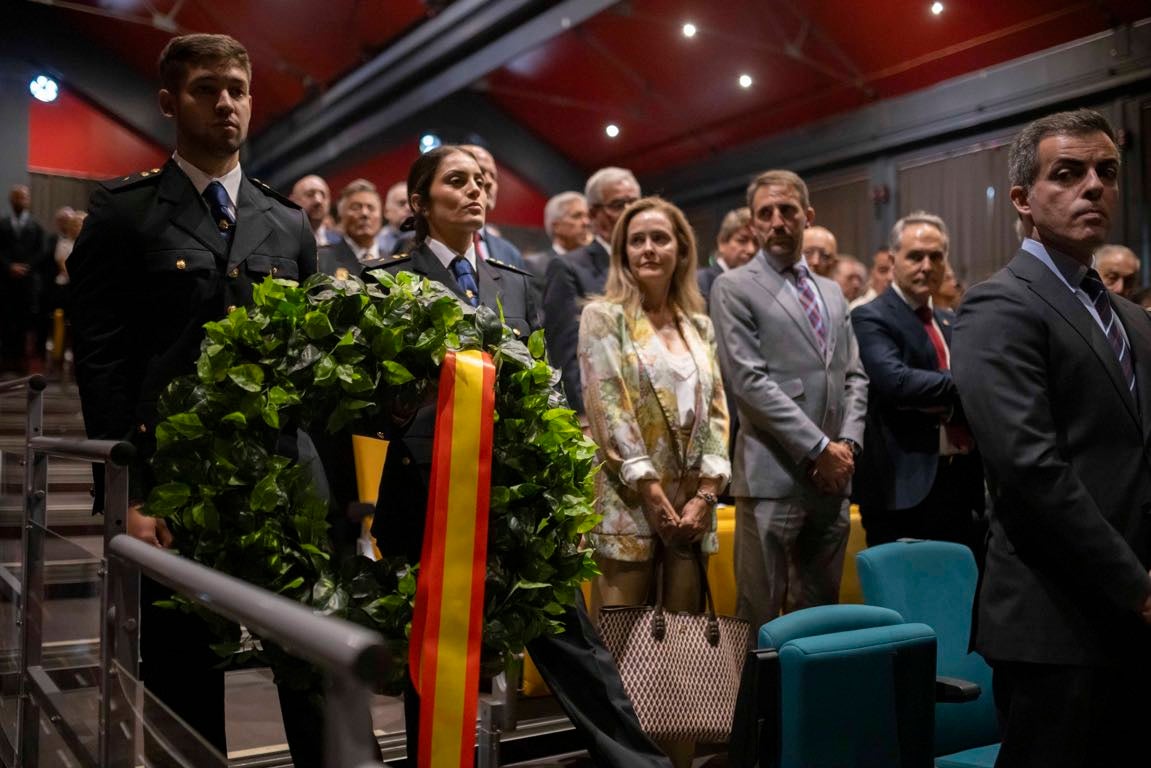Dos agentes portan una corona de flores durante el homenaje a los caídos