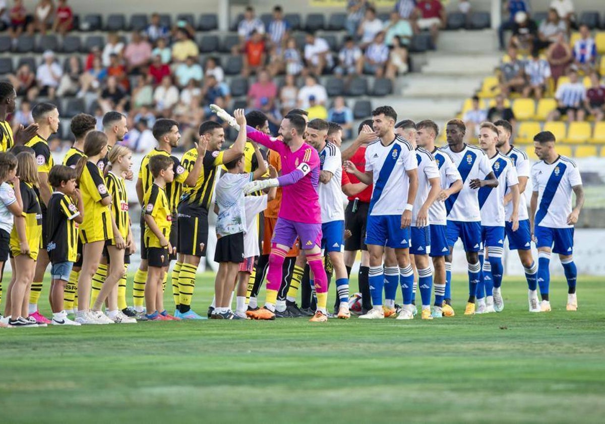 La plantilla del Recreativo saluda a la del San Roque antes del Trofeo de la Bella