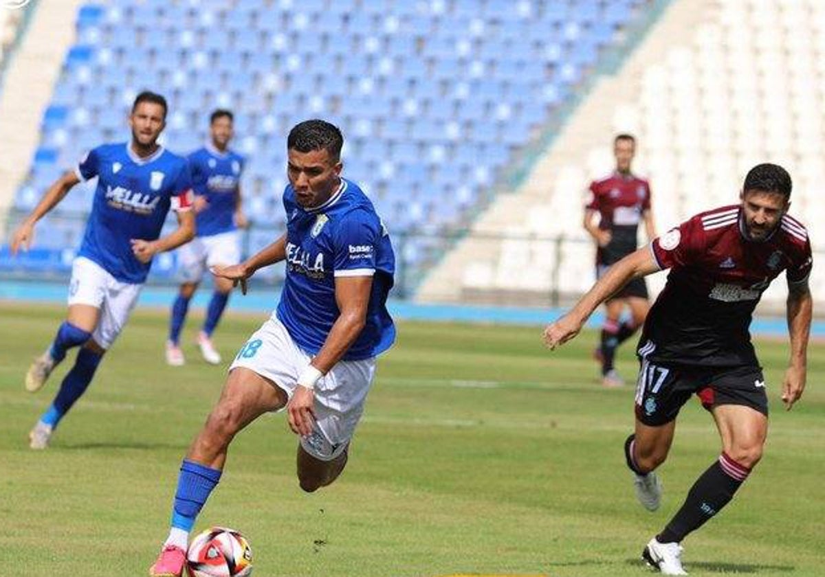 Raúl Navas persiguiendo a Siddiki durante el Melilla-Recreativo de Huelva