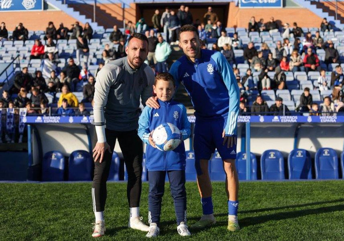 Rubén Gálvez e Iago Díaz con un joven seguidor del Recreativo agraciado con un balón