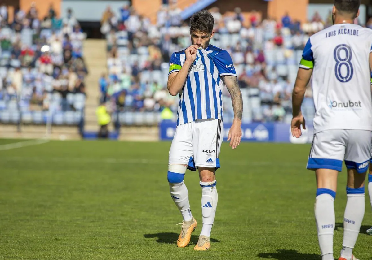 Caye Quintana se besa el escudo del Recreativo tras anotar uno de sus dos goles ante el Melilla
