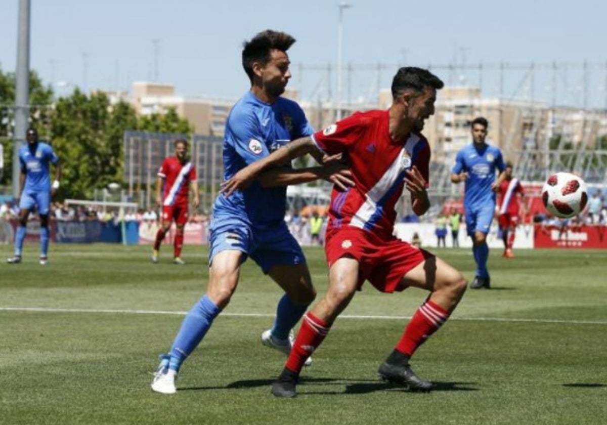 Alberto Quiles presionado por David Prieto durante el Fuenlabrada-Recreativo del año 2019