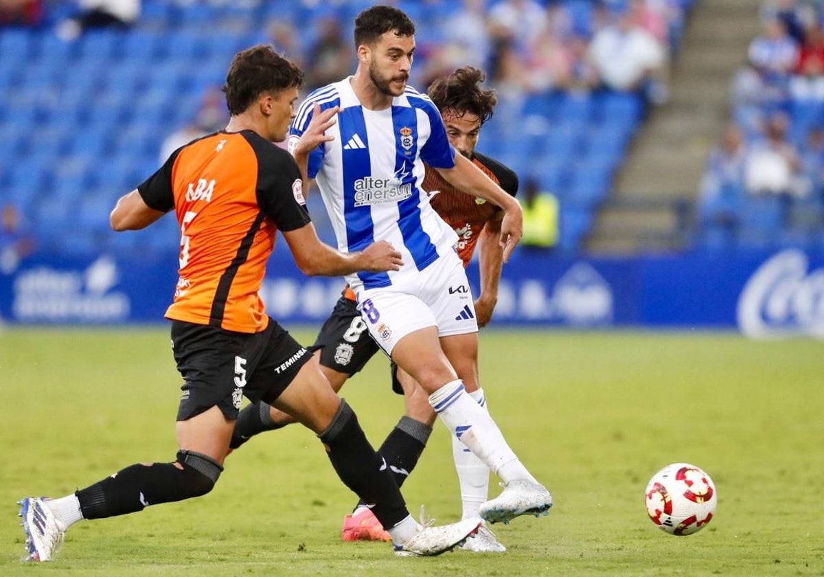 Luis Alcalde, autor del gol del Recreativo, presionado por dos rivales del Fuenlabrada