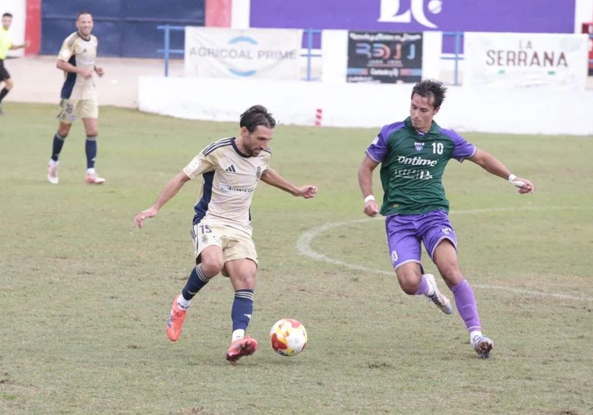 Álex Bernal presionado por un adversario en un lance del partido La Unión Atlético-Recreativo