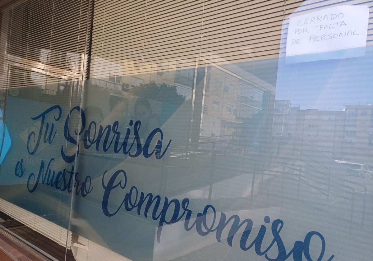 Dentaluz, situada en la calle José Fariña de Huelva capital, con el cartel de 'Cerrado por falta de personal'