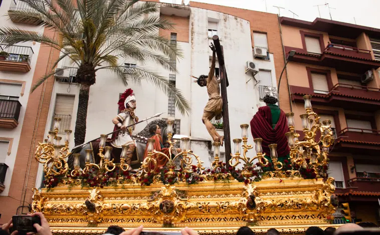 Imagen principal - El paso de misterio del Santísimo Cristo de la Lanzada, nazarenos con paraguas y una fiel llorando