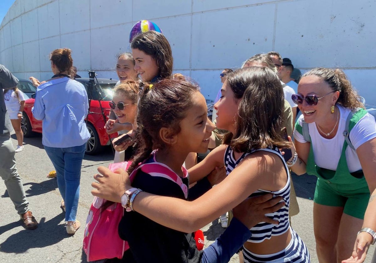 Una niña saharaui y otra onubenses se abrazan